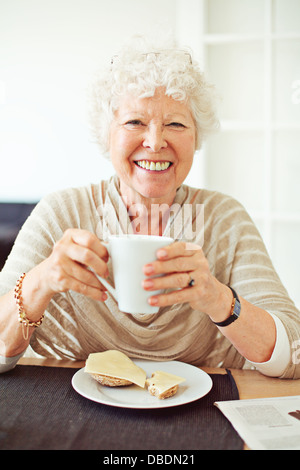 Lächeln alte Dame, die ihr Frühstück zu Hause Stockfoto