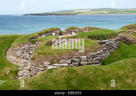 Skara Brae neolithischen Dorf auf Orkney Festland mit der Bucht von Skaill im Hintergrund. Stockfoto