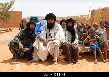 Tuareg Dorfvorsteher mit einer Gruppe von ältesten und Schulkinder in der Mitte des Dorfes compound, Osten Mali, Westafrika Stockfoto