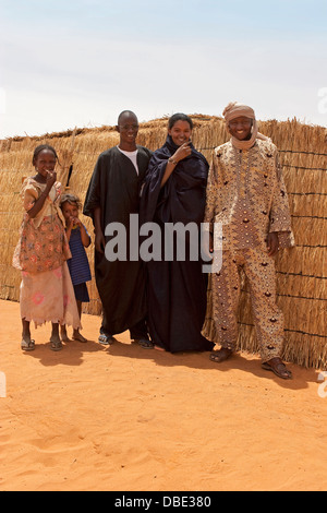 Gruppe der malischen Dorfbewohner aus Nord-Ost-Mali in traditioneller Kleidung vor Holz gerahmt gewebte Matten Hütte, Westafrika Stockfoto