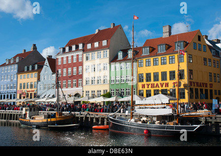 Dänemark. Kopenhagen. Indre durch. Nyhavn. Menschenmengen versammelten sich in den Cafés und Restaurants am Wasser entlang. Stockfoto