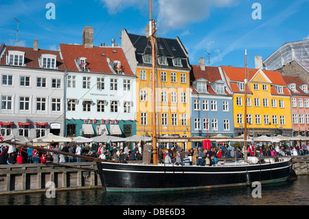 Dänemark. Kopenhagen. Indre durch. Nyhavn. Menschenmengen versammelten sich in den Cafés und Restaurants am Wasser entlang. Stockfoto