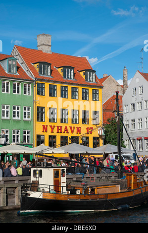 Dänemark. Kopenhagen. Indre durch. Nyhavn. Menschenmengen versammelten sich in den Cafés und Restaurants am Wasser entlang. Stockfoto