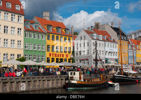Dänemark. Kopenhagen. Indre durch. Nyhavn. Menschenmengen versammelten sich in den Cafés und Restaurants am Wasser entlang. Stockfoto