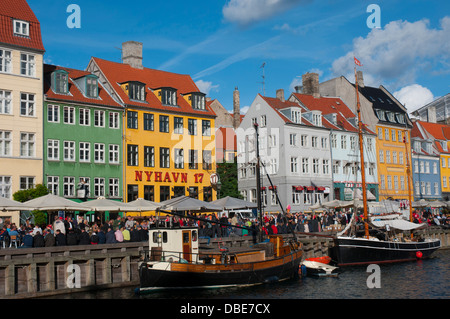 Dänemark. Kopenhagen. Indre durch. Nyhavn. Menschenmengen versammelten sich in den Cafés und Restaurants am Wasser entlang. Stockfoto