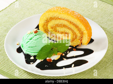 Biskuitrolle Kuchen mit grünen Sorbet und Schokoladensauce Stockfoto