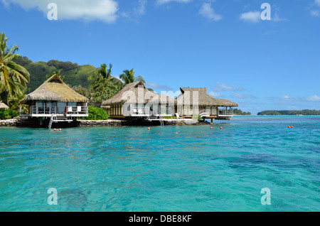 Luxus strohgedeckten Dach Flitterwochen Bungalows in einem Urlaubsort in der blauen Lagune von der tropischen Insel Moorea. Stockfoto