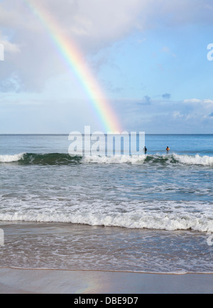 Surfer in Hanalei Bay auf Kauai bewundern Regenbogen Stockfoto