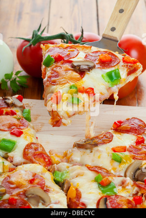 Stück oberste Pizza wird angehoben Stockfoto