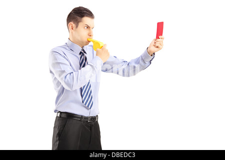 Junger Mann bläst eine Pfeife und eine rote Karte zeigen Stockfoto