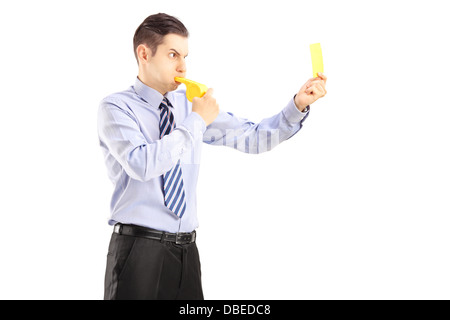 Junger Mann bläst eine Pfeife und eine gelbe Karte zeigen Stockfoto