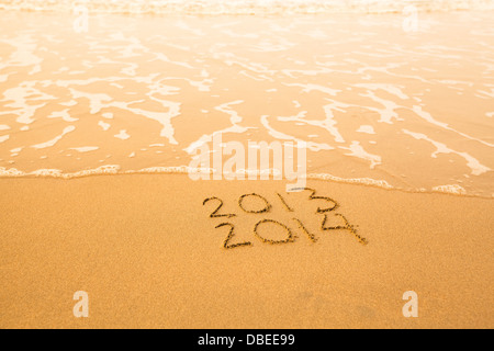 2013 - 2014 - geschrieben im Sand am Strand Textur - weiche Welle des Meeres. Stockfoto