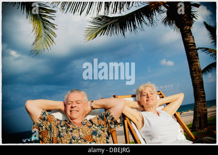 Älteres Ehepaar entspannend am tropischen Strand Stockfoto