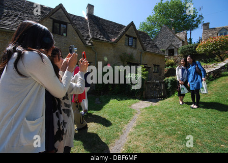 Asiatische Touristen am Arlington Row, ikonischen Zeile des 17. Jahrhunderts Cotswolds Ferienhäuser in Bibury, Vereinigtes Königreich Stockfoto