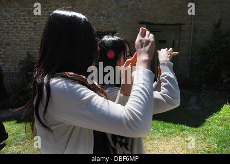 Asiatische Touristen am Arlington Row, ikonischen Zeile des 17. Jahrhunderts Cotswolds Ferienhäuser in Bibury, Vereinigtes Königreich Stockfoto