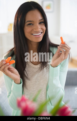 Gemischte Rassen Frau mit Karotten-sticks Stockfoto