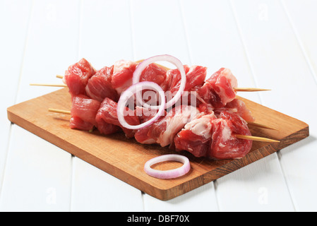 Rohes Schweinefleisch-Spieße auf Schneidebrett Stockfoto