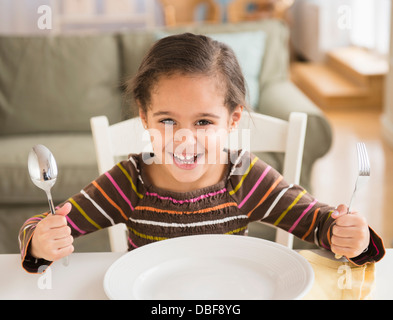 Hispanischen Mädchen anspruchsvolle Speisen am Tisch Stockfoto