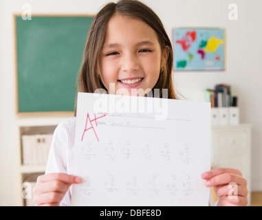 Gemischte Rassen Mädchen Papier mit A + Klasse halten Stockfoto