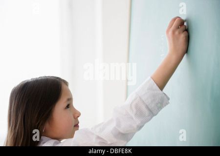 Gemischte Rassen Mädchen an Tafel schreiben Stockfoto