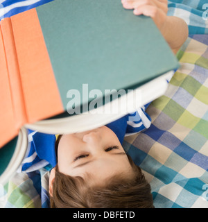 Hispanische Junge liest am Bett Stockfoto