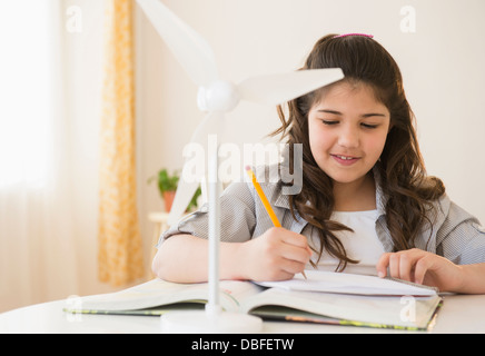 Hispanischen Mädchen mit Modell Windkraftanlage Hausaufgaben Stockfoto