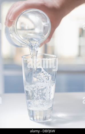 Hispanic Mann Glas Wasser gießen Stockfoto