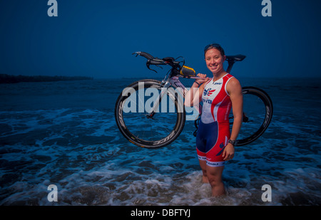 Capt Hila Levy, 35. Operations Support Squadron, posiert mit ihrem Triathlon-Rennrad im Pazifischen Ozean bei Miss Veedol Beach, Japan, 25. Juli 2013. Abgabe qualifiziert zu konkurrieren in der Ironman-WM 2013 am 12. Okt. in Kailua-Kona, Hawaii- Stockfoto