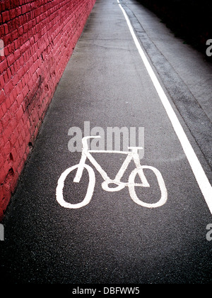 Fahren Sie Weg-Symbol auf einem britischen Gehweg Pflaster mit einer festen weißen Linie den Radweg von der Fussweg trennt. Stockfoto