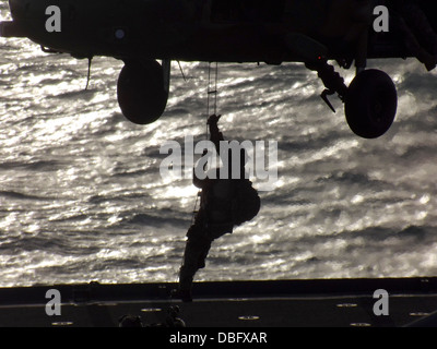 Ein australische Armee Soldaten aus dem 2. Kommando-Regiment, inländische Terrorismusbekämpfung schnell-Abseilen von einer S-70A-9 Black Hawk an Bord dock Landungsschiff USS Germantown (LSD-42). Germantown ist auf Streife mit der Bonhomme Richard Expeditionary Strike Group und Stockfoto