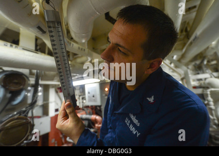 US Navy Elektroniker / 3. Klasse Jonathan Stremel prüft die Temperatur in der Welle-Gasse an Bord der Lenkflugkörper Stockfoto