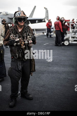 US Marine Aviation Maschinist ist Mate 2. Klasse Forrest Schlitten, zugewiesen, der Strike Fighter Squadron (VFA) 147, 15. Juli 2013 mit Ketten auf dem Flugdeck des Flugzeugträgers USS Nimitz (CVN-68) in den Golf von Oman steht. Die Nimitz wurde in eingesetzt. Stockfoto