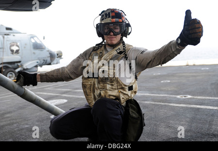 US Marine Aviation strukturelle Mechaniker 2. Klasse Dallas Leavitt, zugewiesen, der Strike Fighter Squadron (VFA) 147, gibt eine Daumen-hoch nach der Endkontrolle eine F/A-18F Super Hornet Flugzeuge auf dem Flugdeck des Flugzeugträgers USS Nimitz (CVN-68) in t Stockfoto