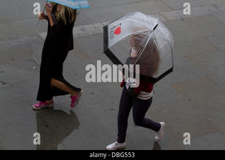 London UK. 30. Juli 2013. Frauen mit Sonnenschirmen überqueren Trafalgar Square, wie London mit heftigen Regenfälle nach Wochen der hohen Temperaturen Kredit getroffen wird: Amer Ghazzal/Alamy Live-Nachrichten Stockfoto