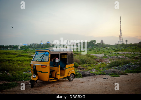 Eine gelbe Auto-Rikscha ist am Strand von Marina in der südlichen indischen Stadt Chennai geparkt. Stockfoto