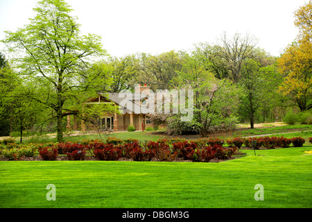 schönes Haus im Wald mit gepflegten Rasen Stockfoto