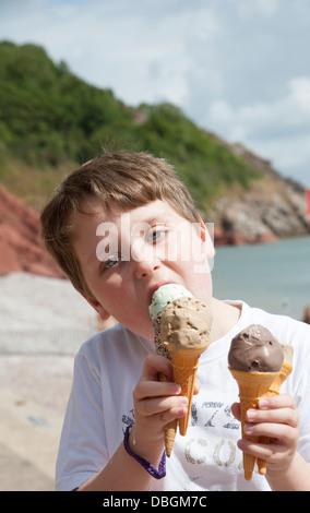 Junge essen Eis Kornette am Meer UK Stockfoto