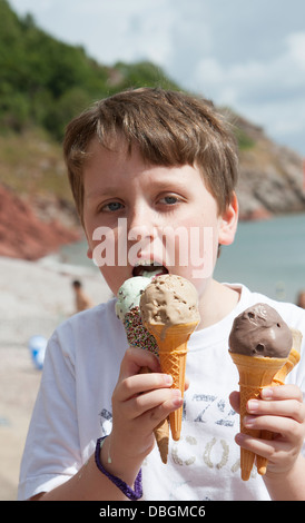 Junge essen Eis Kornette am Meer UK Stockfoto