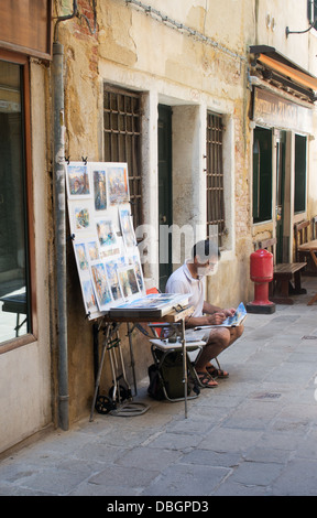 Männliche Künstler Malerei in einer Seitenstraße in Venedig, Italien Stockfoto