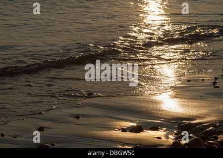 Sonnenuntergang am Sandstrand reflektiert Stockfoto