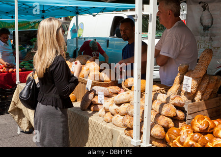 Frau kauft Brote am Bauernmarkt - USA Stockfoto