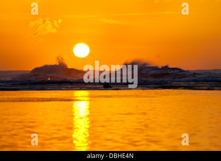 Sonnenuntergang mit hohen Wellen hinter dem Riff und ruhigem Wasser vorne am Ke'e Beach in Kauai, Hawaii. Stockfoto