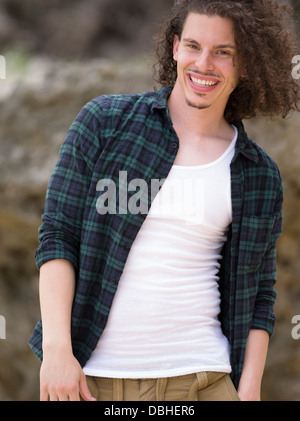 Ägyptischen amerikanischer Mann mit langem lockigem Haar Bart und Schnurrbart Lächeln auf den Lippen tragen check Shirt und weißes t-shirt Stockfoto