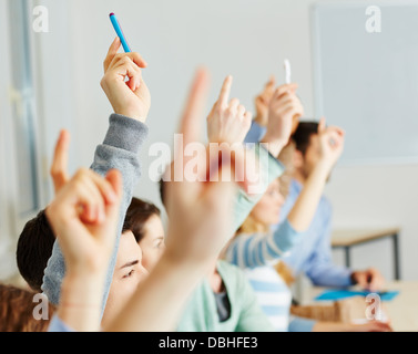 Viele Studenten, die ihre Hände in der Klasse für eine Antwort Stockfoto