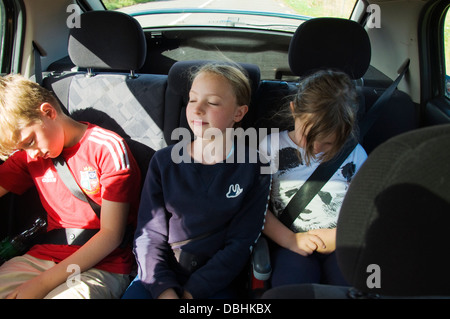 Drei Kinder schlafend im hinteren Rücken Sitze mit Sicherheitsgurte auf Stockfoto