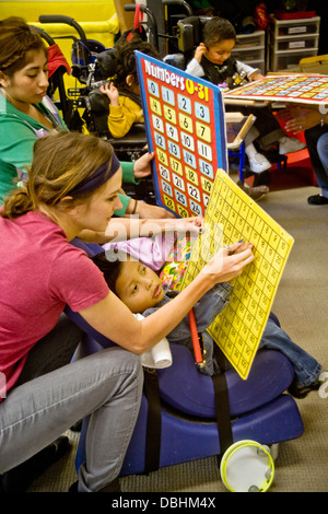 Geschulte Mitarbeiter verwenden taktile Buchstaben, die Schüler spürt auf speziell bedruckten Bogen, lesen und schreiben zu lehren Stockfoto