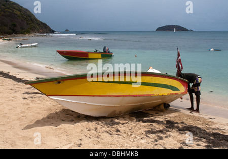 Wartung von einem bunten Speed-Boot am Strand von Salt Whistle Bay Mayreau, die Grenadinen, östlichen Karibik. Stockfoto