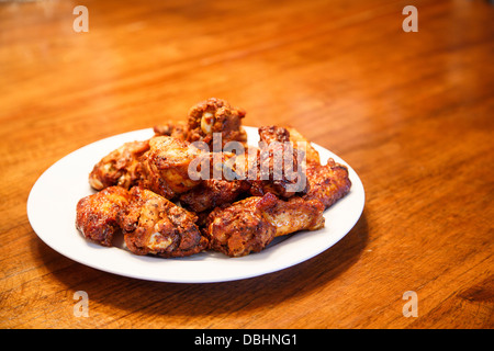 Einen weißen Teller mit würzigen Mesquite gewürzte Hähnchenflügel Stockfoto