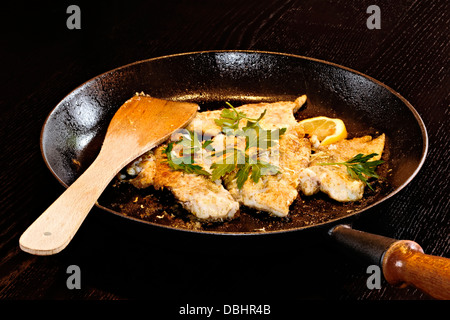 Gebratener Fisch in Pfanne mit Petersilie Stockfoto