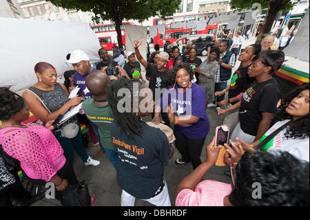 London, UK. 31. Juli 2013. Demonstranten halten eine Mahnwache von Gesang und Tanz in London. Simbabwe geht heute an die Urnen in einer allgemeinen Wahl, die viele glauben, der derzeitige Präsident Robert Mugabe manipuliert wird. Bildnachweis: Lee Thomas/Alamy Live-Nachrichten Stockfoto